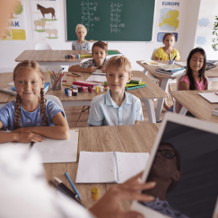 Children in a classroom listen to their teacher