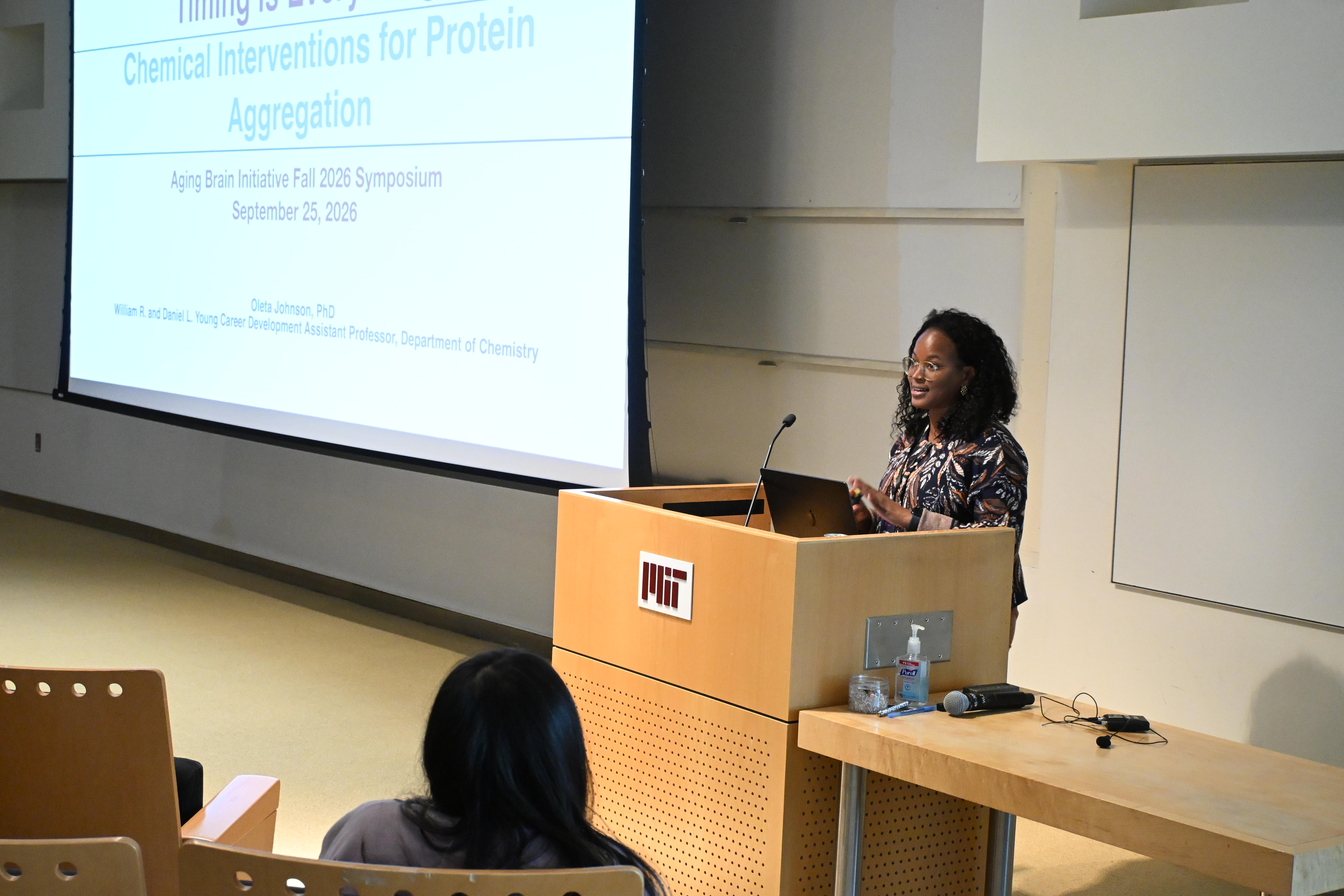 Oleta Johnson standas at a podium in MIT's Building 46 as she begins her talk to the Singleton Auditorium audience