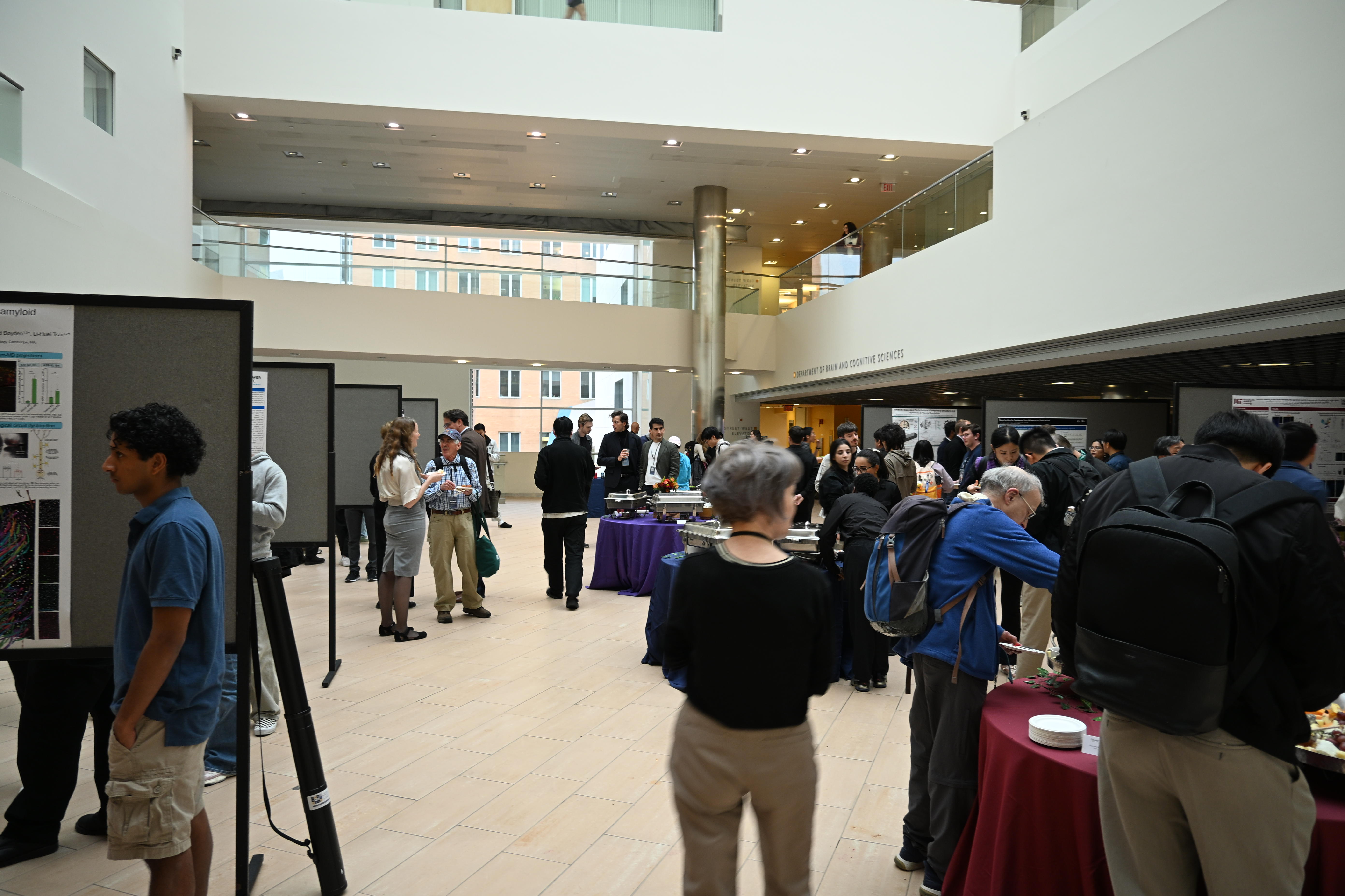 A crowd of people assembled at a poster session featuring Aging Brain Initiative research projects