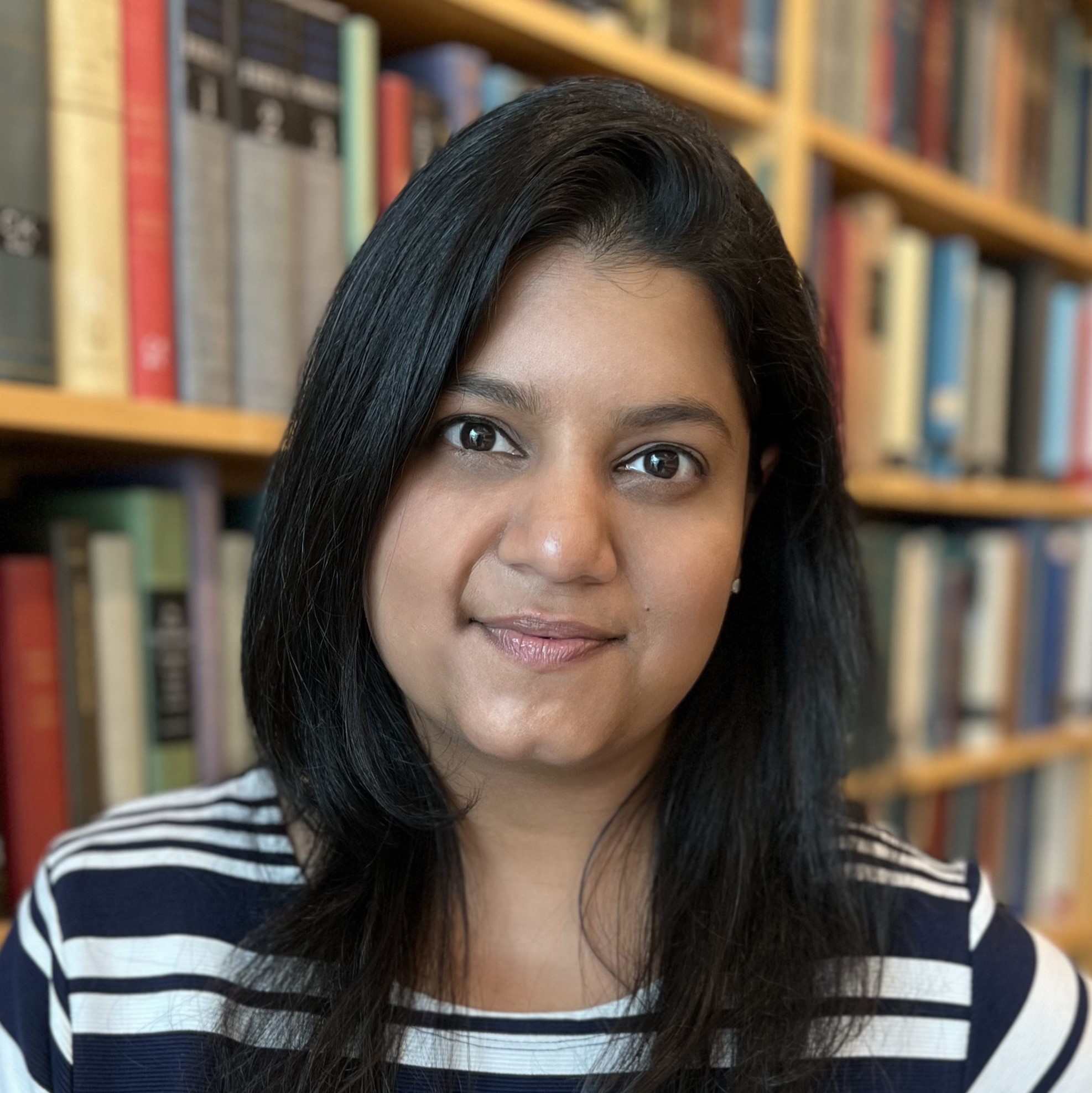 A portrait of Giselle Fernandes standing in a library