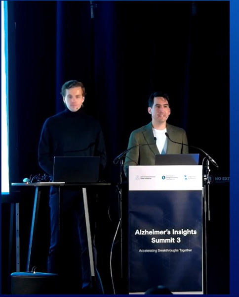 Arvid Gollwitzer and Andre Noriega stand together on stage at a conference