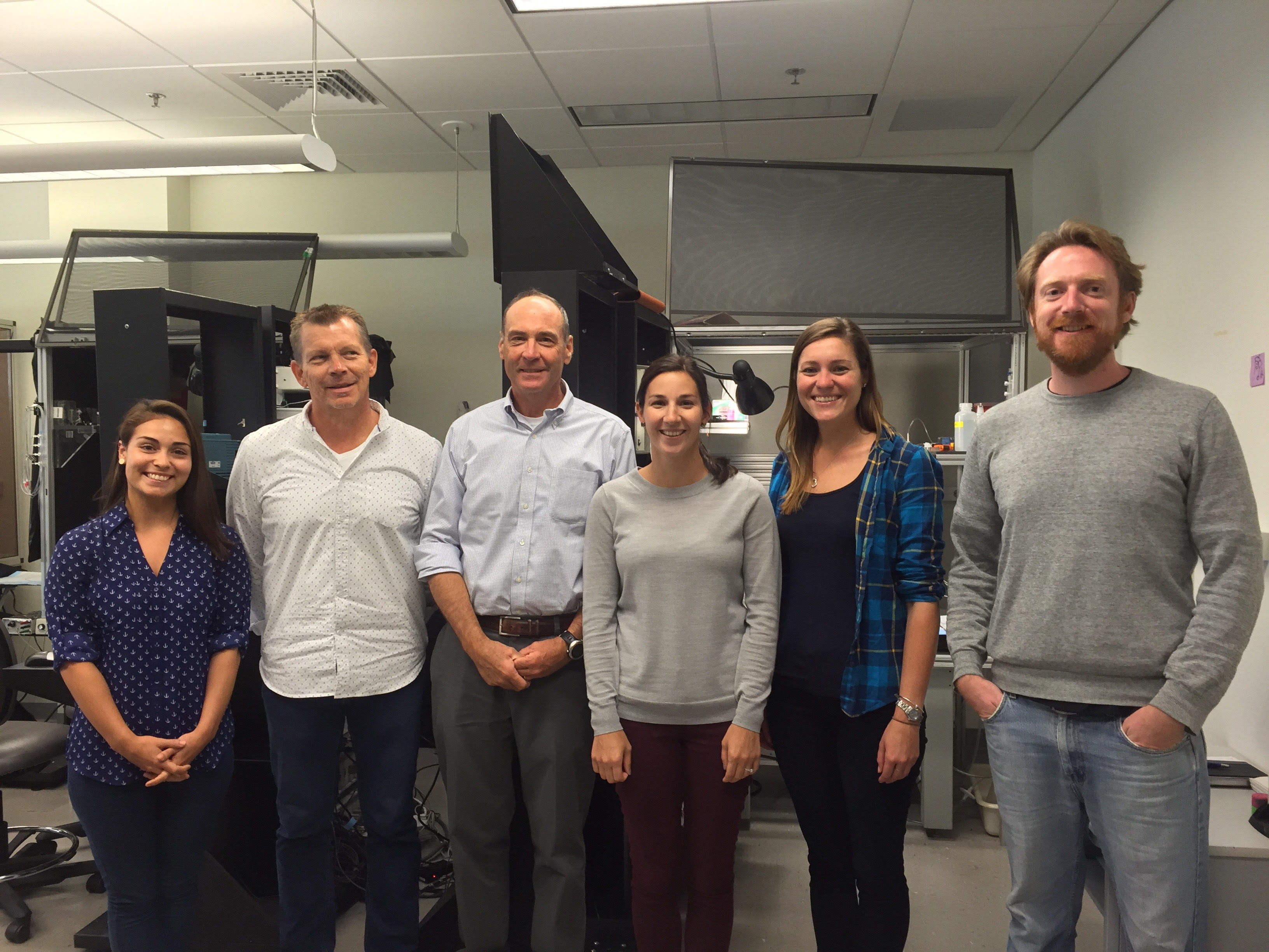 Six researchers in the Bear lab stand shoulder to shoulder in a line