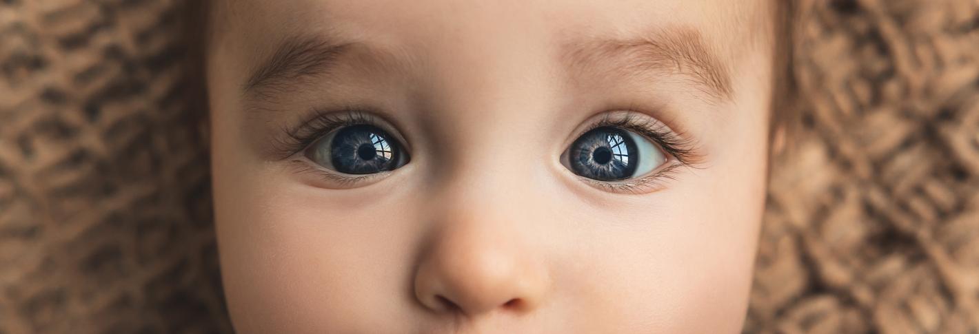 a closeup of a baby with beautiful blue eyes that seem a bit cross-eyed