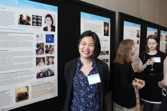 Joyce Wang smiles as she stands next to her poster