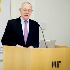 Rafael Reif stands at a lectern with a sign behind him reading Alana Down Syndrome Center