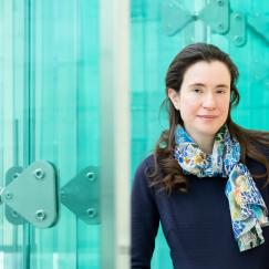 Myriam Heiman stands along the blue glassy windows of the Reading Terrace in MIT's Building 46