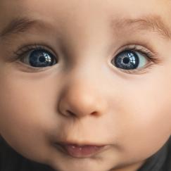 a closeup of a baby with beautiful blue eyes that seem a bit cross-eyed